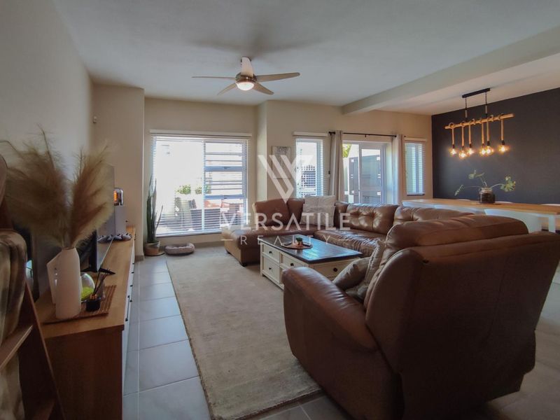 Spacious open-plan living and dining area featuring tiled floors, ceiling fan, and large sliding doors providing access to the outdoor space.