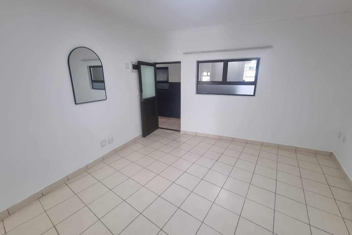 A bright, empty living area featuring neutral tiled flooring and clean white walls, providing a versatile blank canvas for interior design.