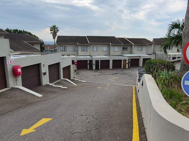View of the townhouse complex driveway and entrance area featuring multiple garage units and paved access.