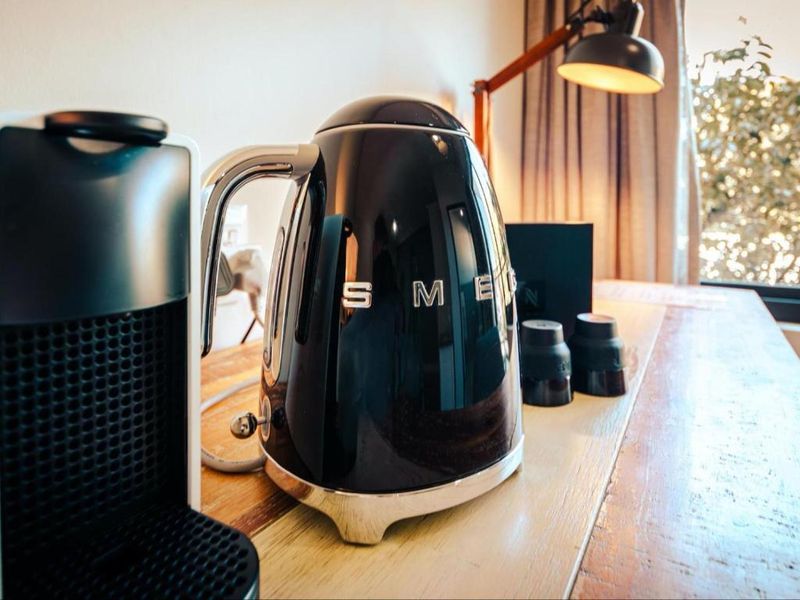 A close-up shot of a black kettle and coffee machine on a wooden surface, focusing on small appliances rather than property infrastructure.