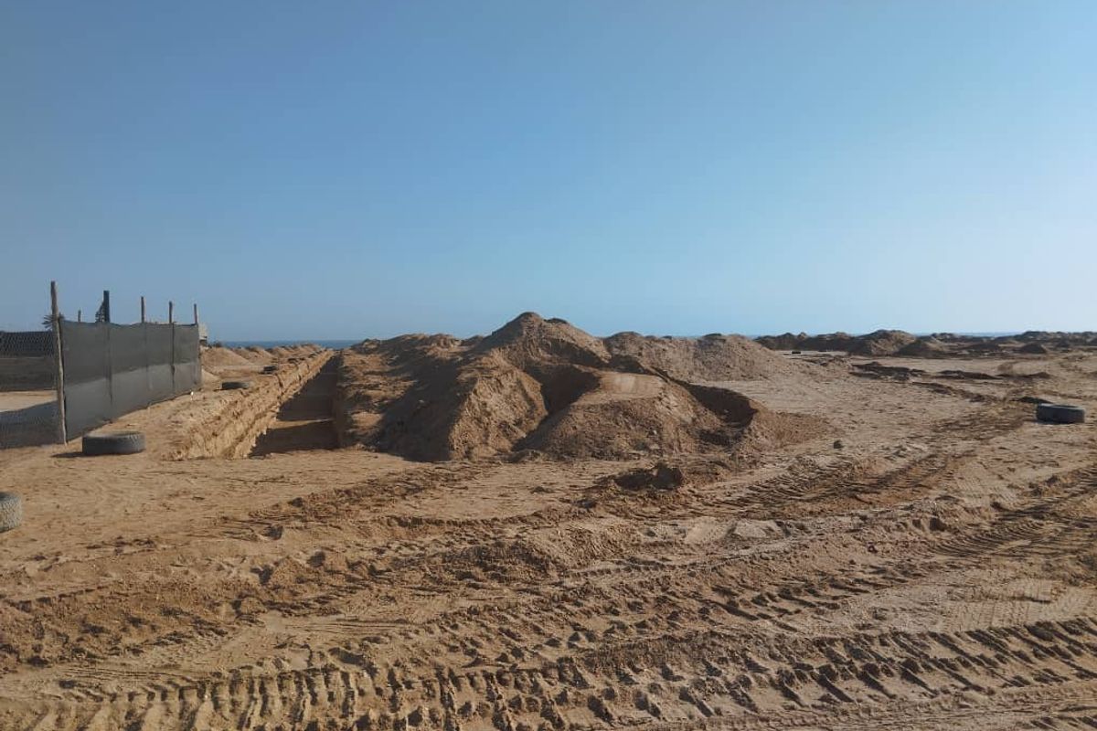 A vacant residential plot featuring significant earthworks, excavation, and perimeter fencing, offering a blank canvas for future development.