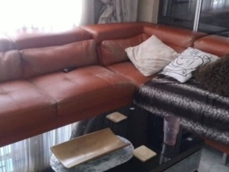 A living room area featuring a large leather sectional sofa.
