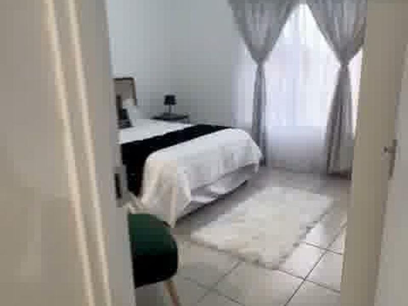 A bedroom featuring tiled flooring and a central ceiling light fixture, viewed from the doorway.