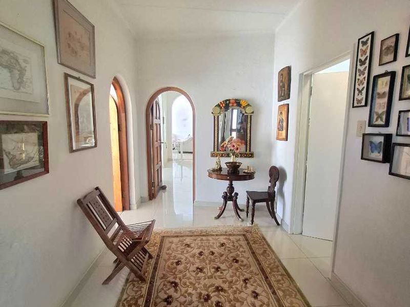 A bright hallway featuring tiled flooring and distinctive arched doorways leading to adjacent rooms.