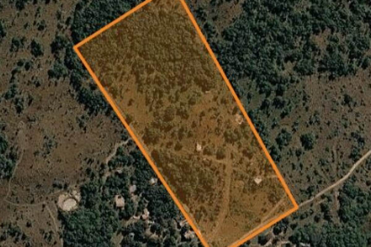 An aerial view showing the demarcated boundary of the small holding property within a natural landscape.