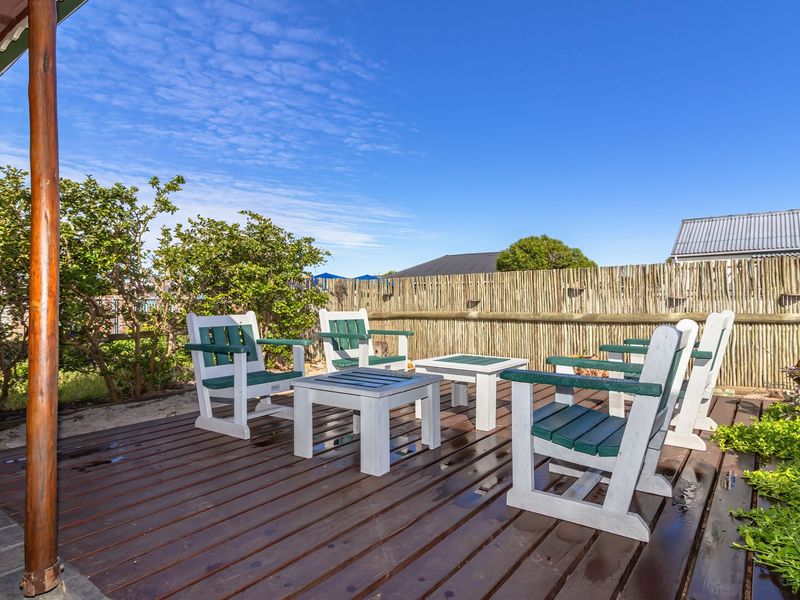 An outdoor timber deck patio area featuring wooden support posts and a natural timber slat privacy fence.