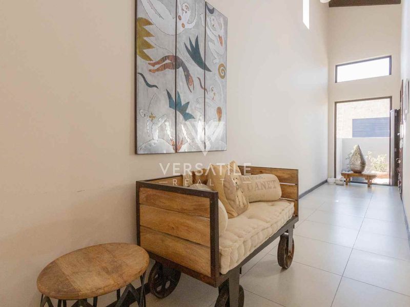 A bright and spacious entrance hall featuring large format floor tiles, high ceilings, and clerestory windows that allow for ample natural light.