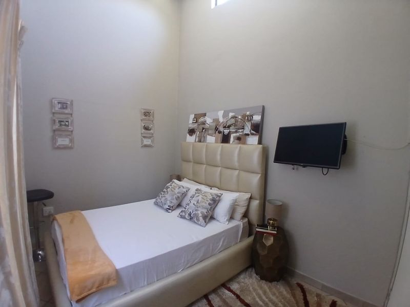 A bedroom featuring a high ceiling with a clerestory window, providing natural light and a sense of vertical space.