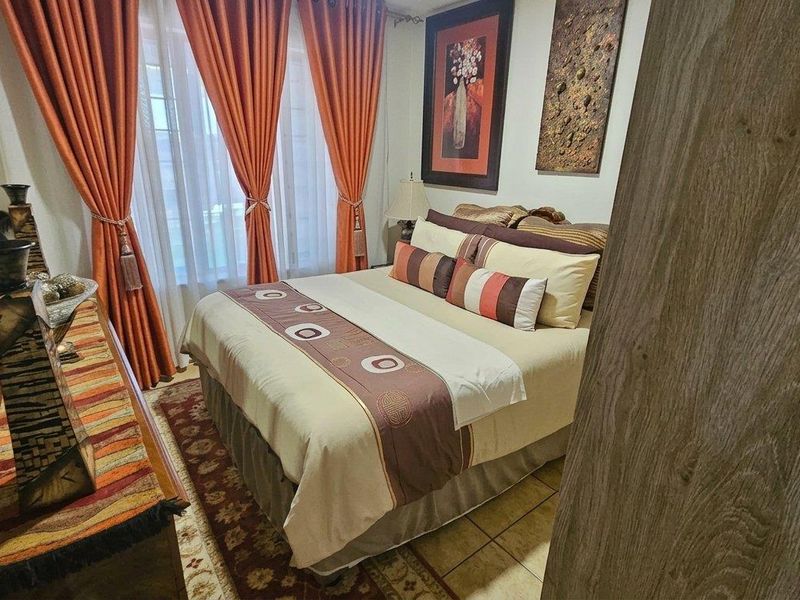 A cozy bedroom featuring tiled flooring and a built-in wardrobe, offering a functional and comfortable living space.