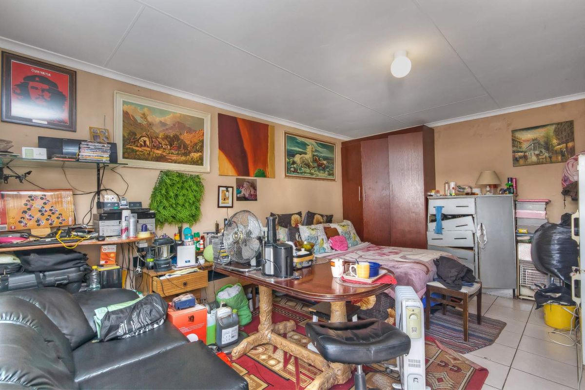 A multi-purpose bedroom space featuring tiled flooring and built-in storage cabinetry.