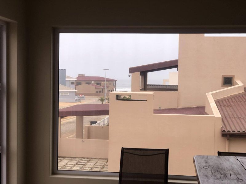 A view from an interior window looking out over the surrounding neighbourhood and coastal area.