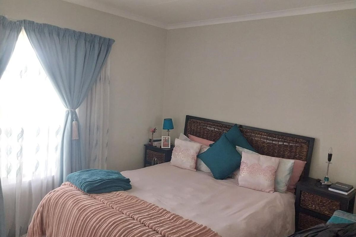 A well-lit bedroom featuring neutral wall tones and classic cove cornicing, providing a comfortable and functional living space.