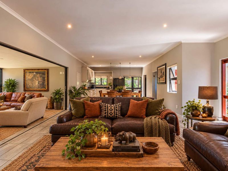 Spacious open-plan living area featuring tiled floors, recessed lighting, and seamless flow to an adjacent lounge and kitchen space.