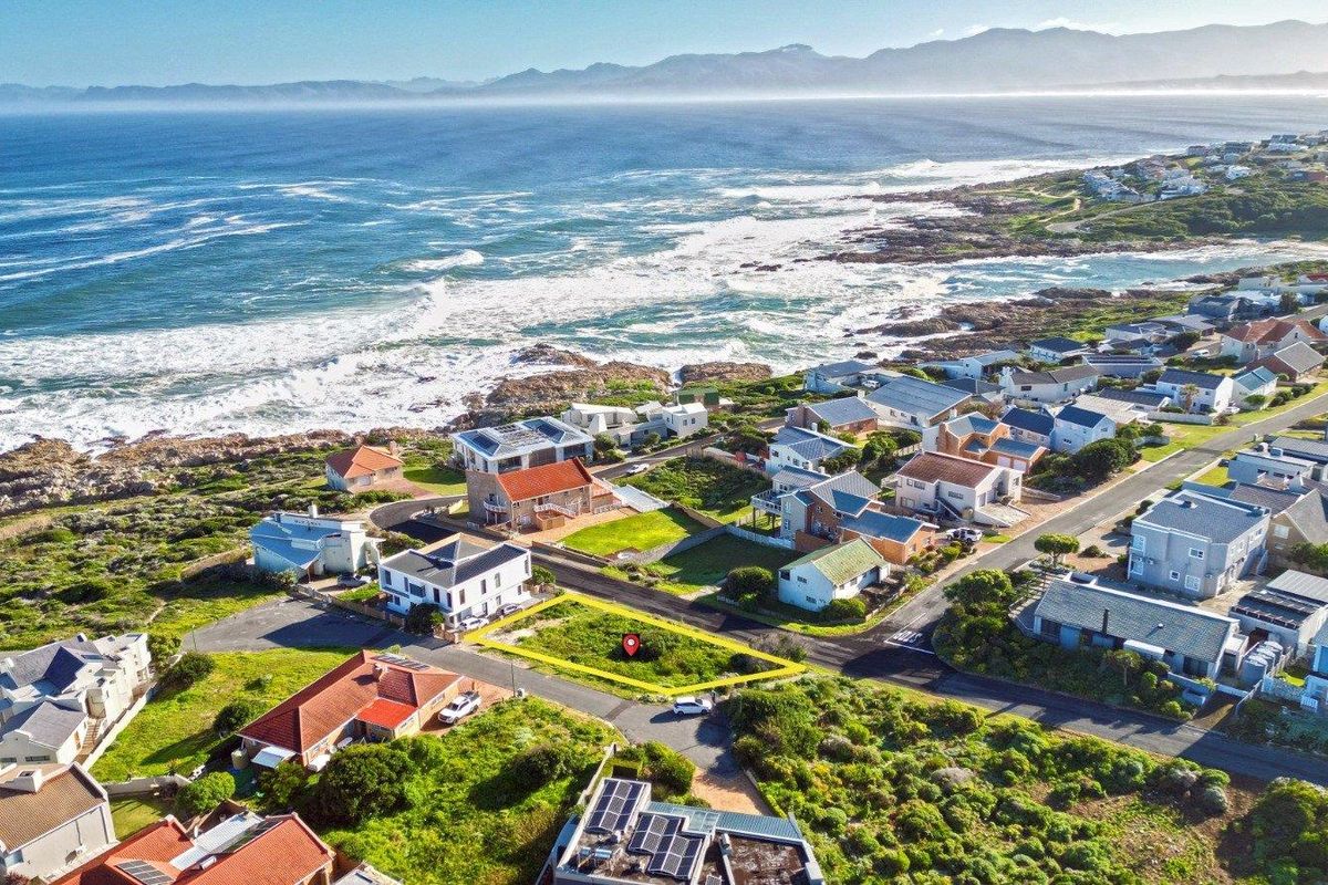 An aerial view of a vacant residential land plot situated in a prime coastal neighborhood with ocean views.