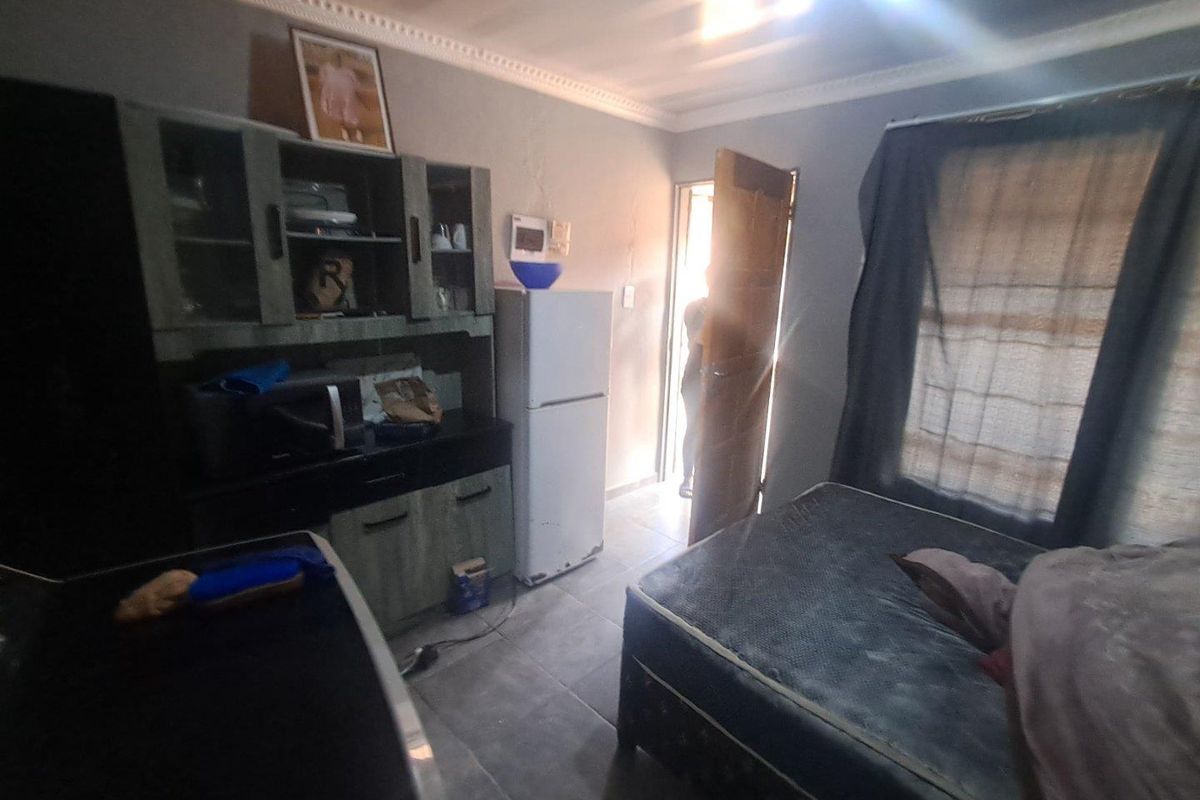 A compact living space featuring tiled flooring, built-in cabinetry, and direct access to an exterior doorway.
