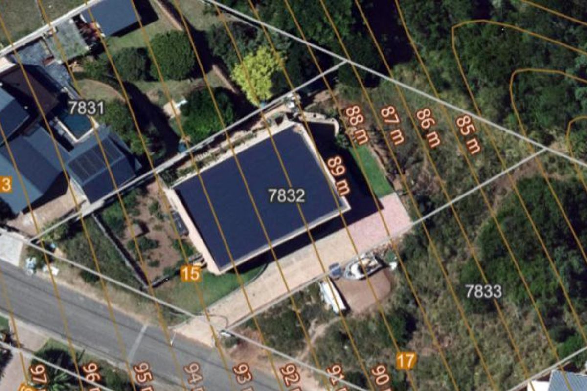 Aerial view of the residential property showing the plot layout, existing structure, and surrounding landscape with topographical contour lines.