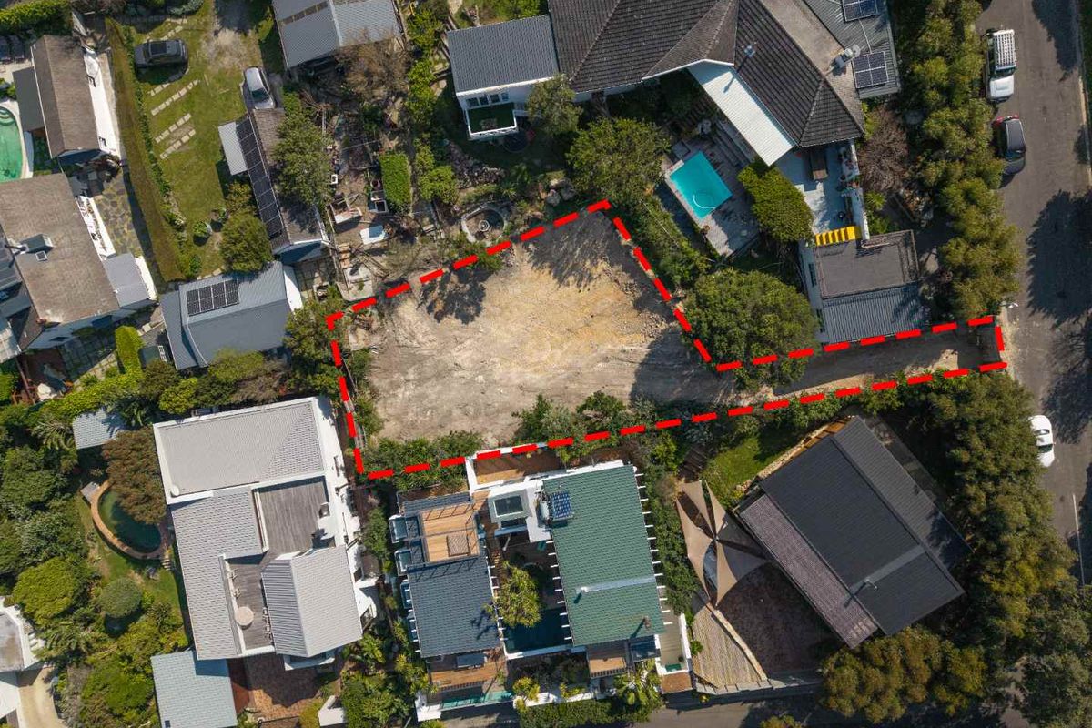 Aerial view of a vacant residential plot situated within an established neighborhood, featuring clear boundaries and access from the street.