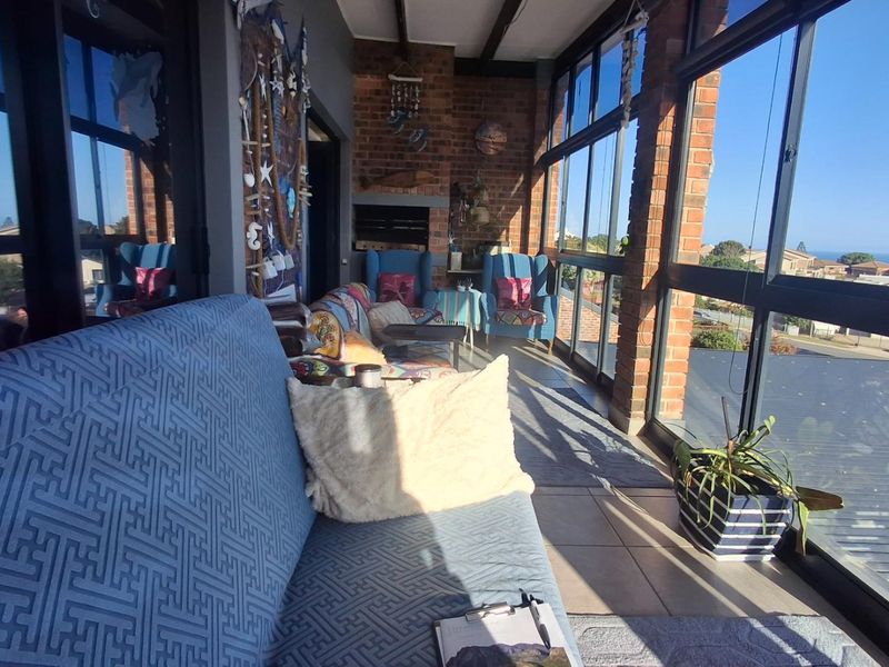 Enclosed patio area featuring exposed brick walls, large windows with natural light, and a built-in fireplace, offering a comfortable space for relaxation.
