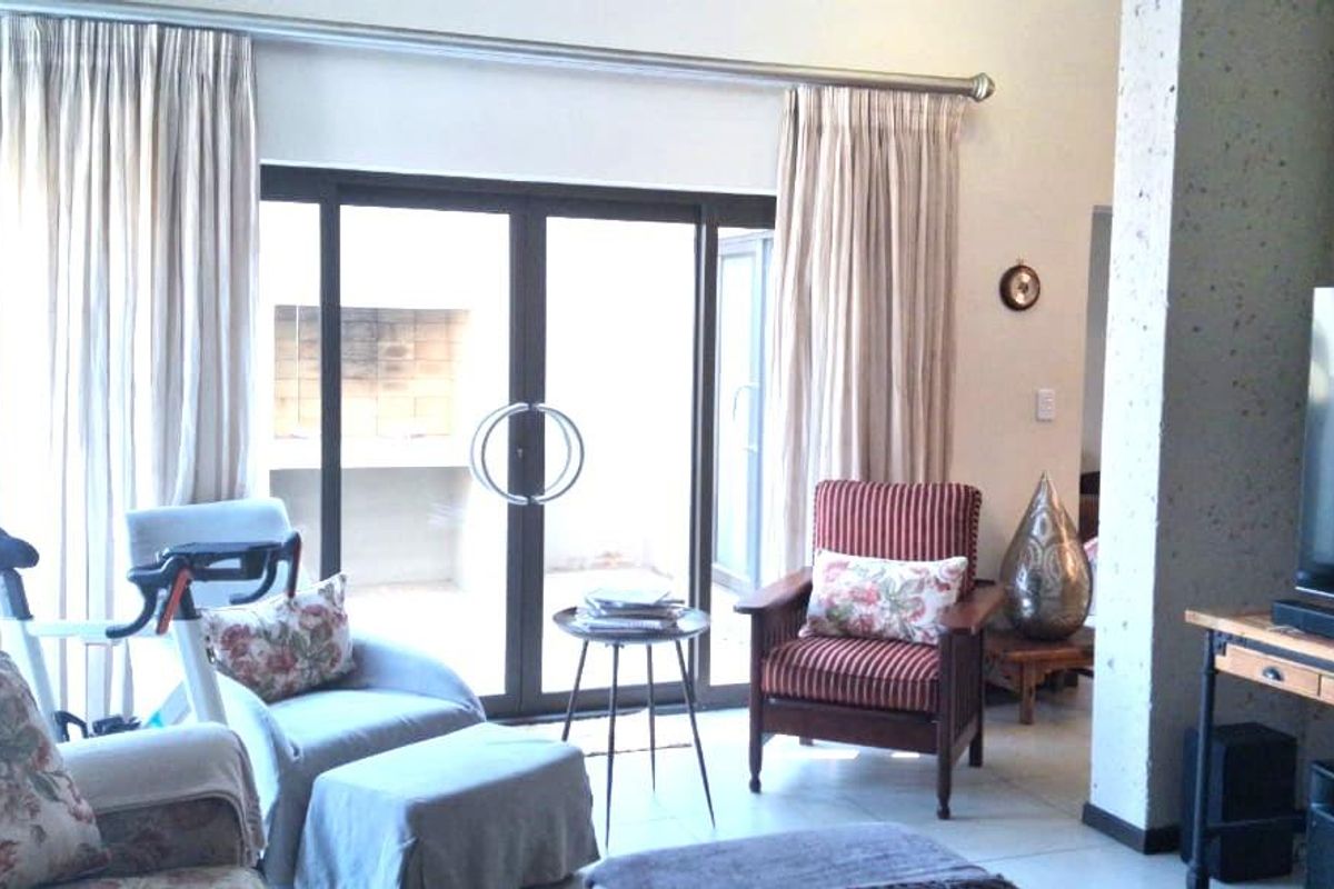 Spacious living room featuring large sliding glass doors that provide natural light and direct access to an outdoor patio area.