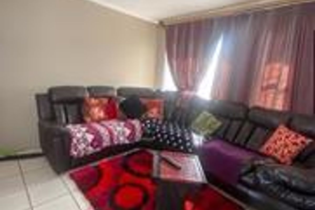 A living room area featuring tiled flooring and neutral wall finishes, providing a functional space for relaxation.