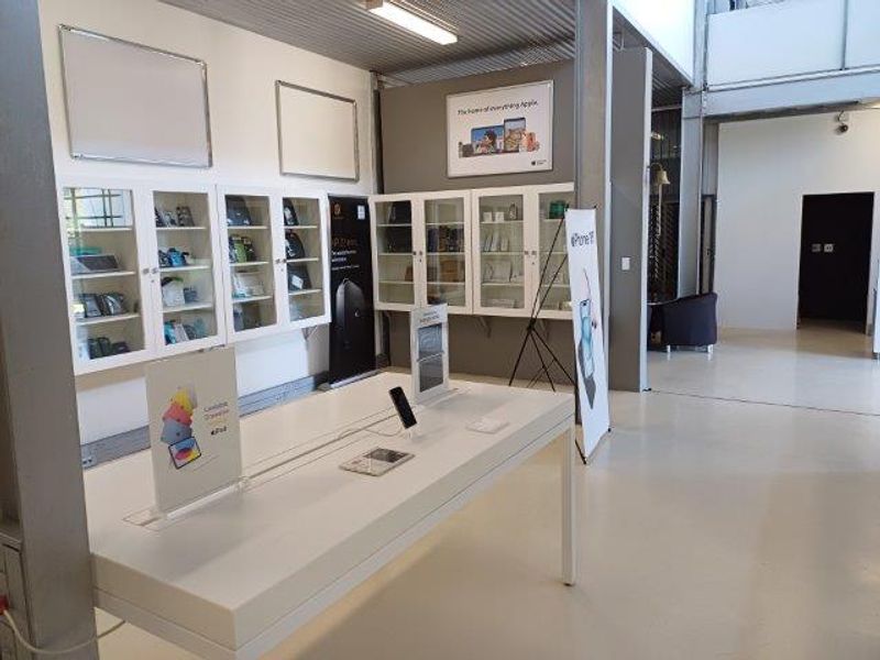 Modern office retail space featuring built-in display cabinetry, polished epoxy flooring, and an open-plan industrial aesthetic with high ceilings.