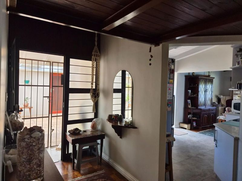 Entrance area featuring timber ceiling, tiled and timber flooring, and direct access to an outdoor patio through a security gate.