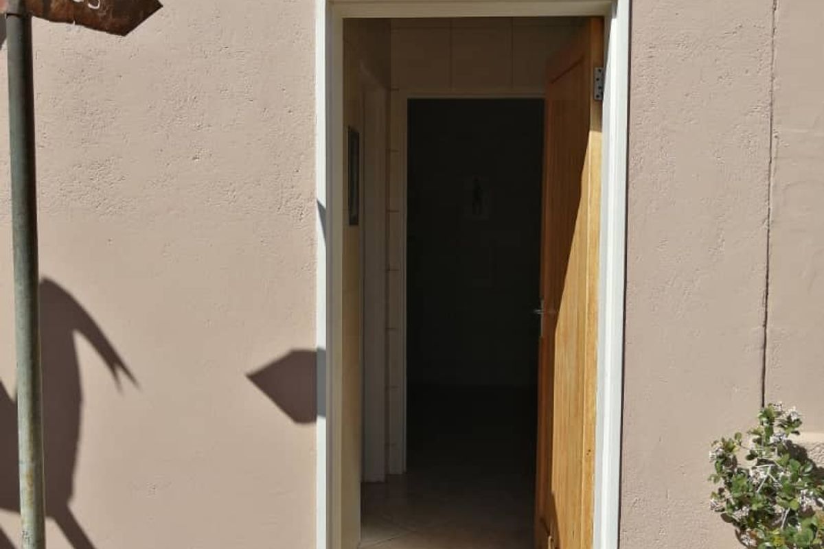 Exterior view of a hotel restroom entrance featuring a wooden door and signage for ladies and gents facilities.