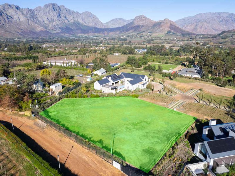 Aerial view of a vacant residential plot featuring clear boundaries, set within a scenic landscape with mountain views.