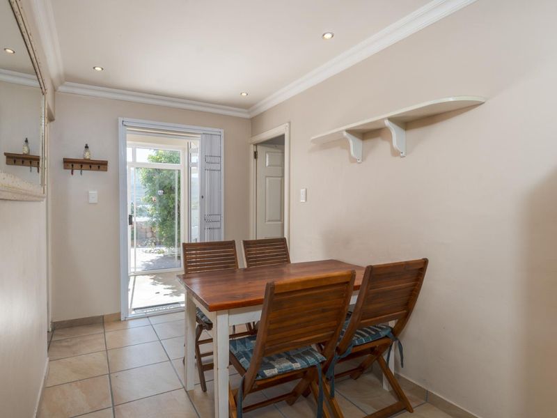 A dining area featuring tiled flooring, recessed downlighting, crown molding, and direct access to an outdoor patio through a glass panel door.