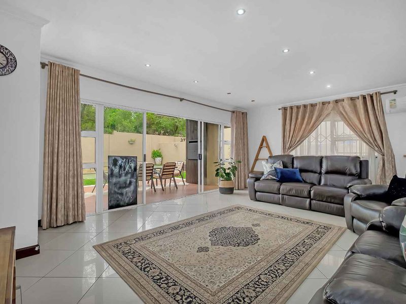 Spacious living room featuring large sliding glass doors that provide seamless access to the outdoor patio area and abundant natural light.