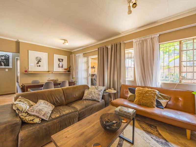 Open-plan living and dining area featuring tiled floors, neutral wall tones, and direct access to an outdoor patio through a sliding glass door.