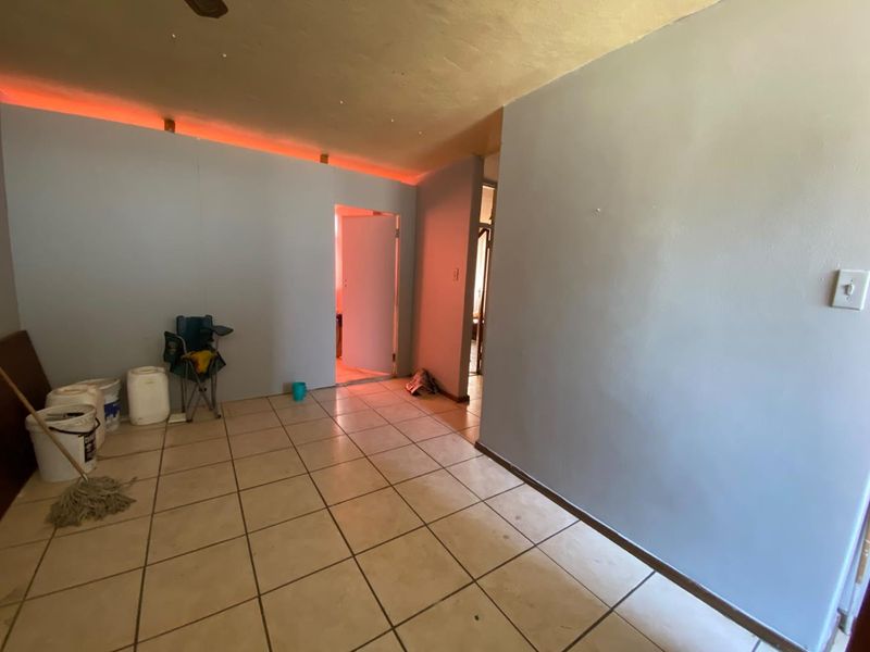 An empty living area featuring ceramic floor tiles and integrated LED strip lighting, providing a blank canvas for potential interior design updates.