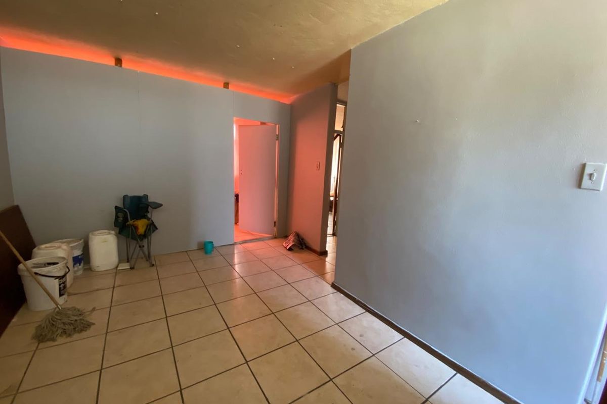An empty living area featuring ceramic floor tiles and integrated LED strip lighting, providing a blank canvas for potential interior design updates.