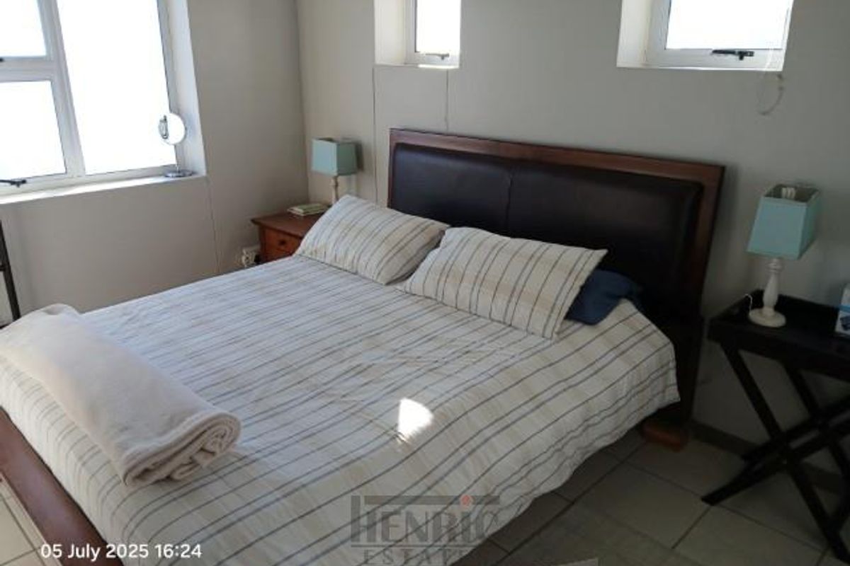 A bedroom featuring tiled flooring and multiple windows providing natural light.