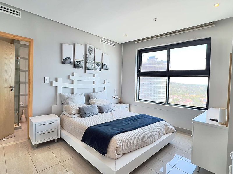 A well-maintained bedroom featuring tiled flooring, ducted air conditioning, recessed lighting, and a large window with views.