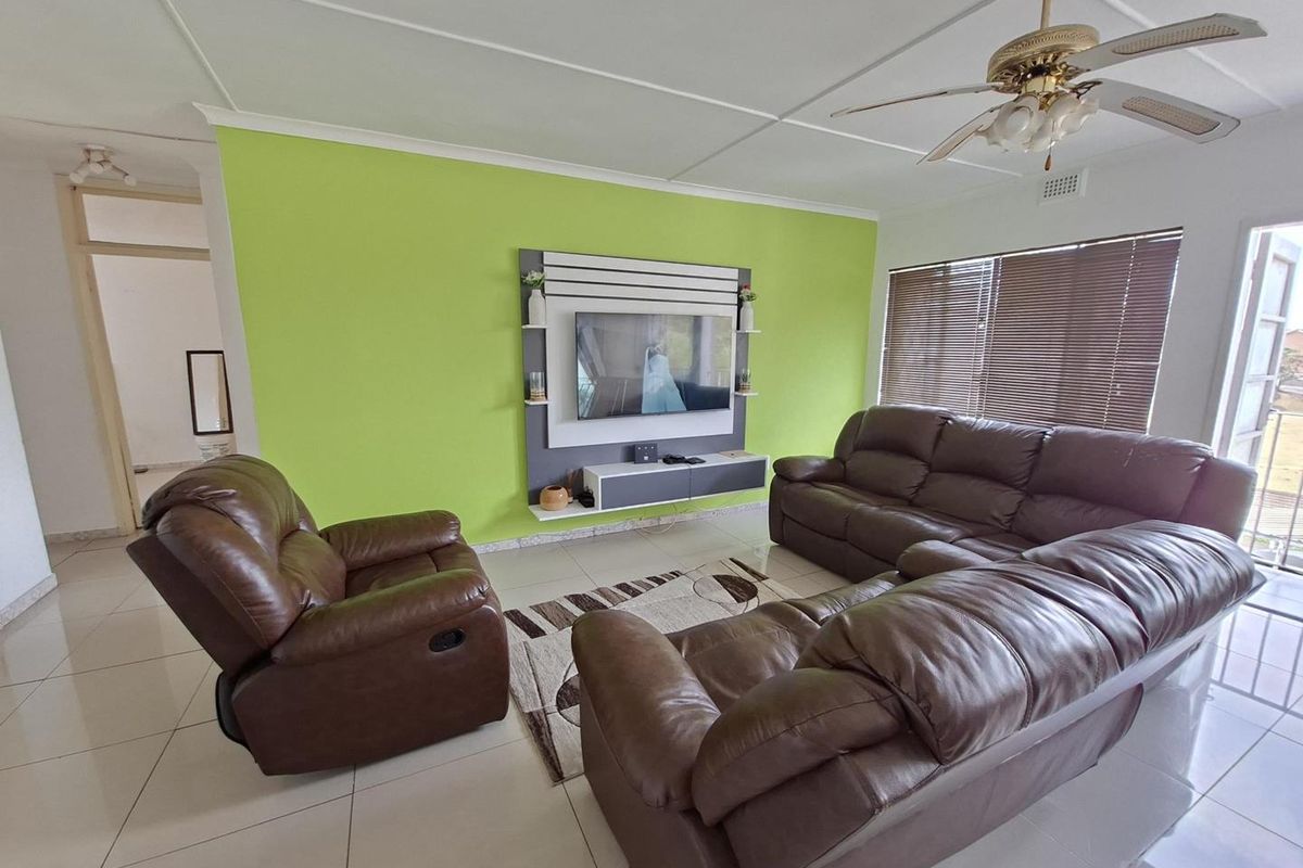 A living room featuring tiled flooring, a ceiling fan, venetian blinds, and a built-in media console unit.