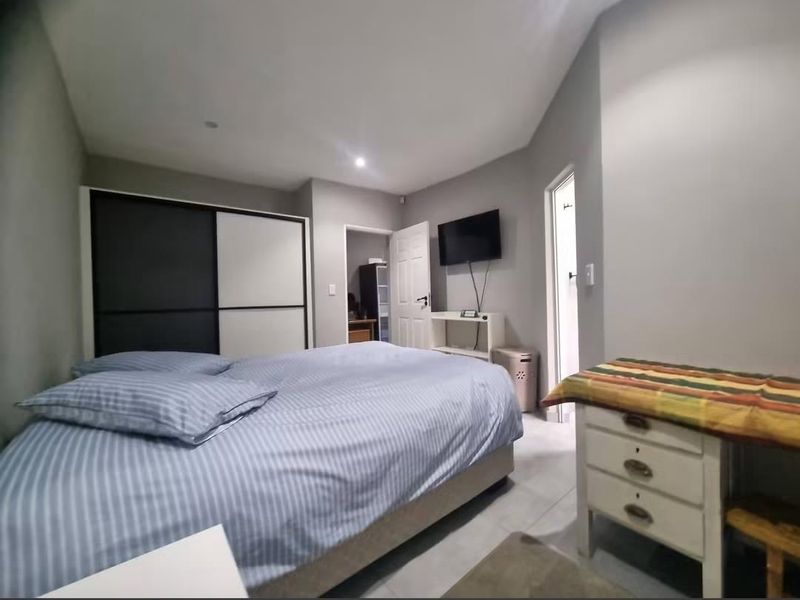 A bedroom featuring tiled flooring, recessed downlighting, and a built-in sliding door wardrobe.