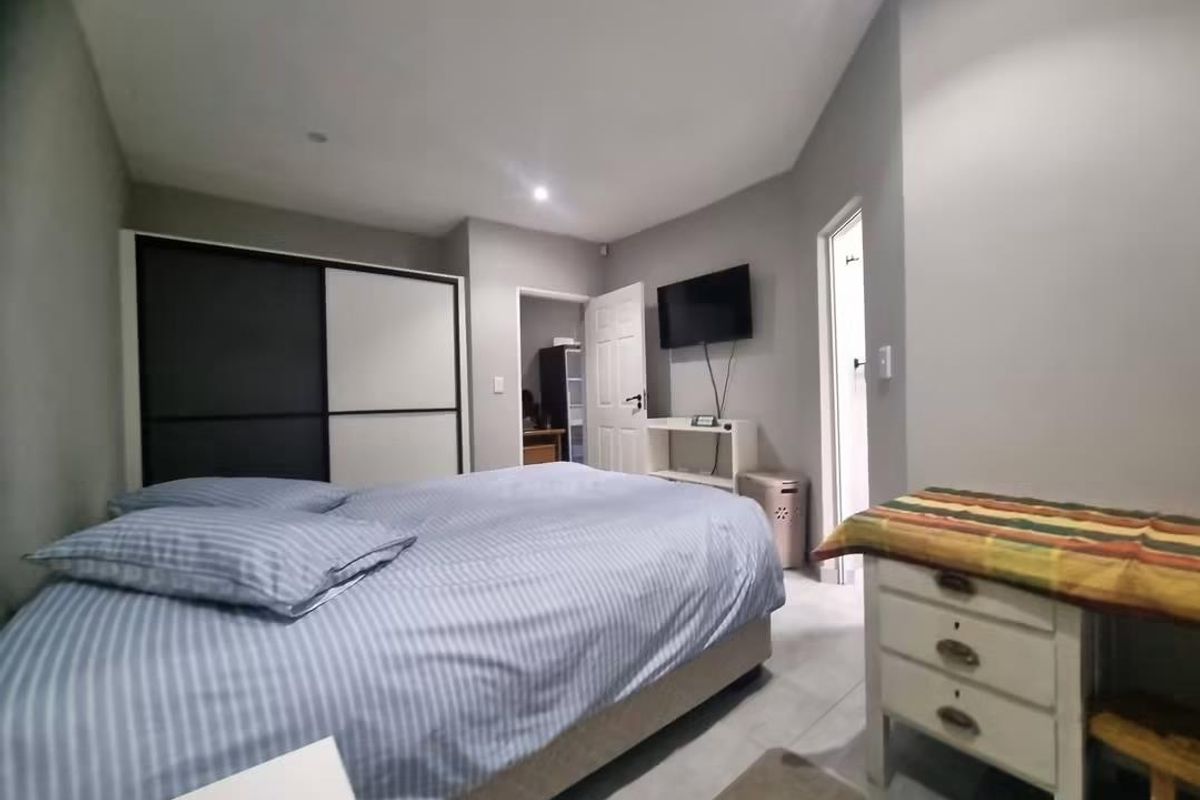 A bedroom featuring tiled flooring, recessed downlighting, and a built-in sliding door wardrobe.