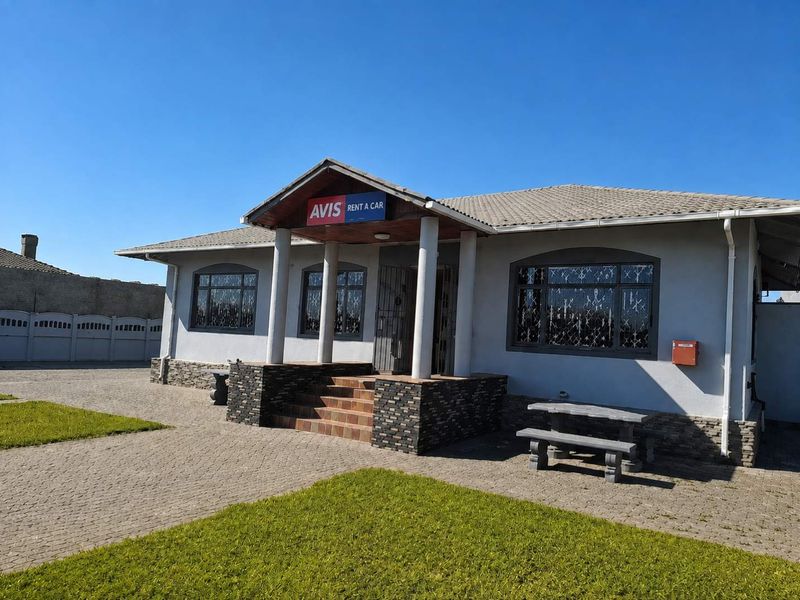 Front exterior view of a commercial property featuring a covered entrance porch, stone cladding accents, and paved driveway area.