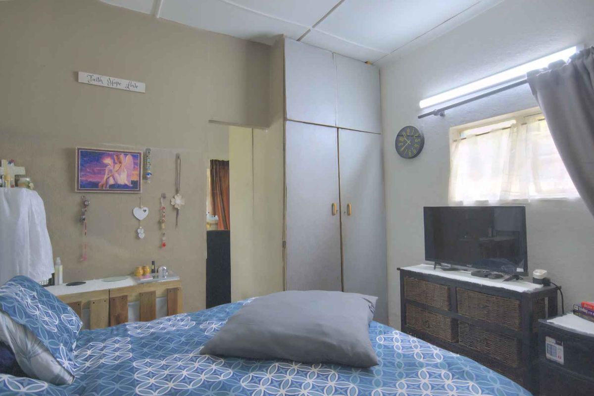 A bedroom featuring built-in cupboards, a window with natural light, and standard ceiling finishes.