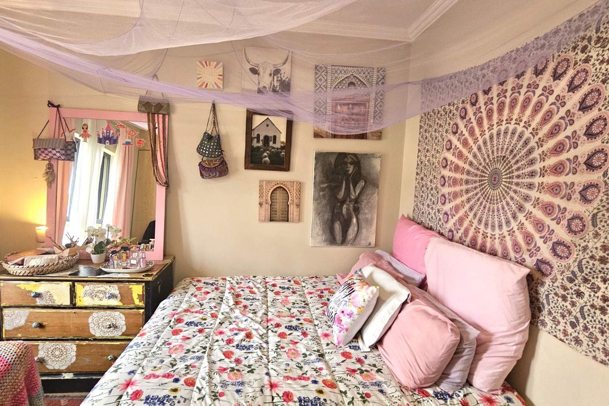 A cozy bedroom featuring neutral walls, crown molding, and a window with natural light, providing a comfortable and inviting sleeping space.