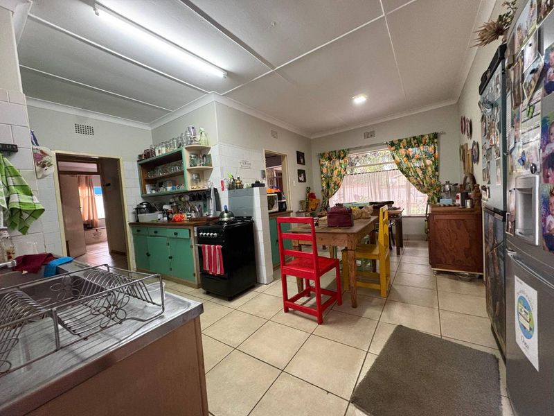 Open plan kitchen and dining area featuring tiled flooring, built-in cabinetry, and a functional layout with direct access to adjacent rooms.
