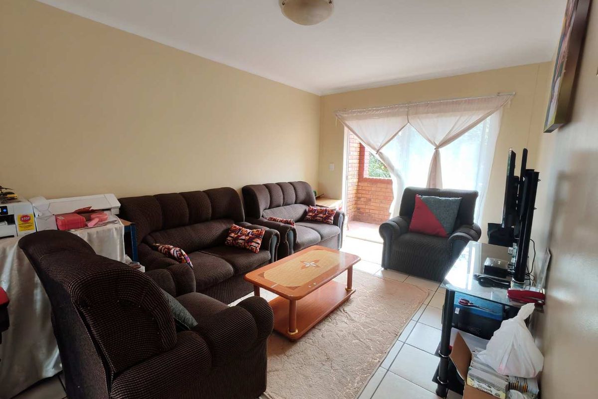 A living room featuring tiled flooring and a sliding door providing access to an outdoor patio area.