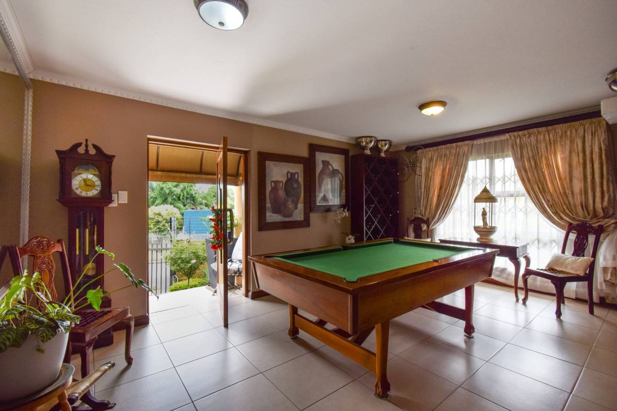 A spacious living area featuring tiled flooring, crown molding, and direct access to an outdoor patio space.