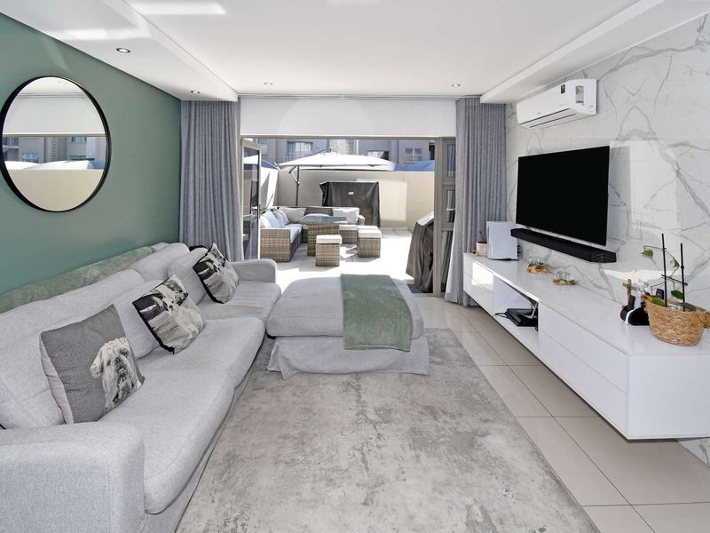 Modern living room featuring a marble-look feature wall, recessed lighting, split-system air conditioning, and seamless access to an outdoor patio area.