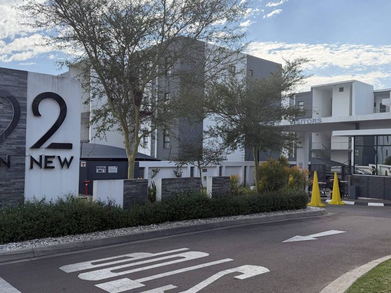 The main entrance and security gatehouse of the 92 on New apartment complex, featuring modern signage and controlled access.