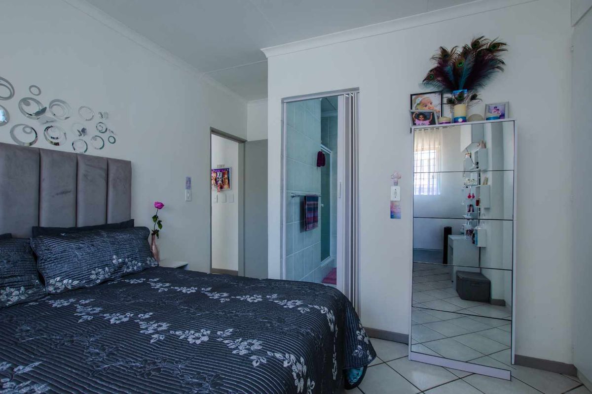 A bedroom featuring tiled flooring and direct access to an en-suite bathroom through a folding door.