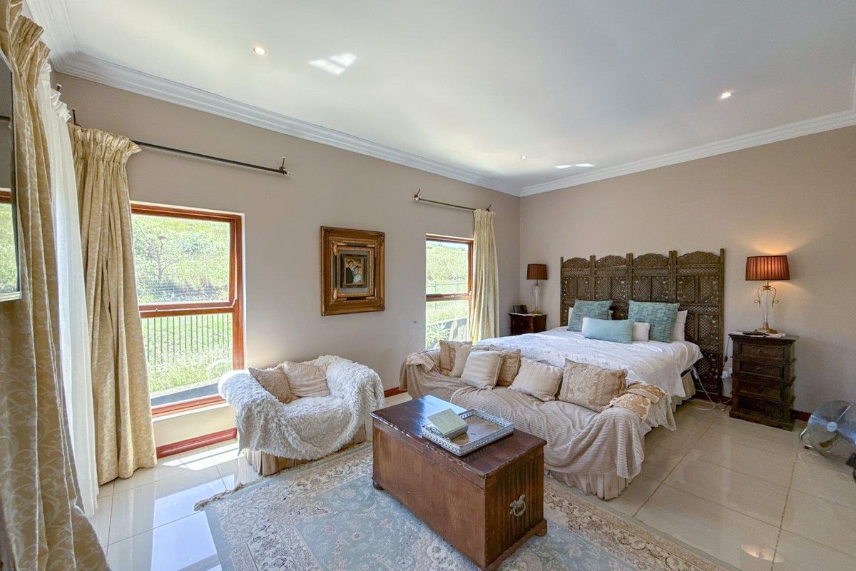 Spacious bedroom featuring large windows, tiled flooring, recessed ceiling lighting, and crown molding, offering a bright and comfortable living space.