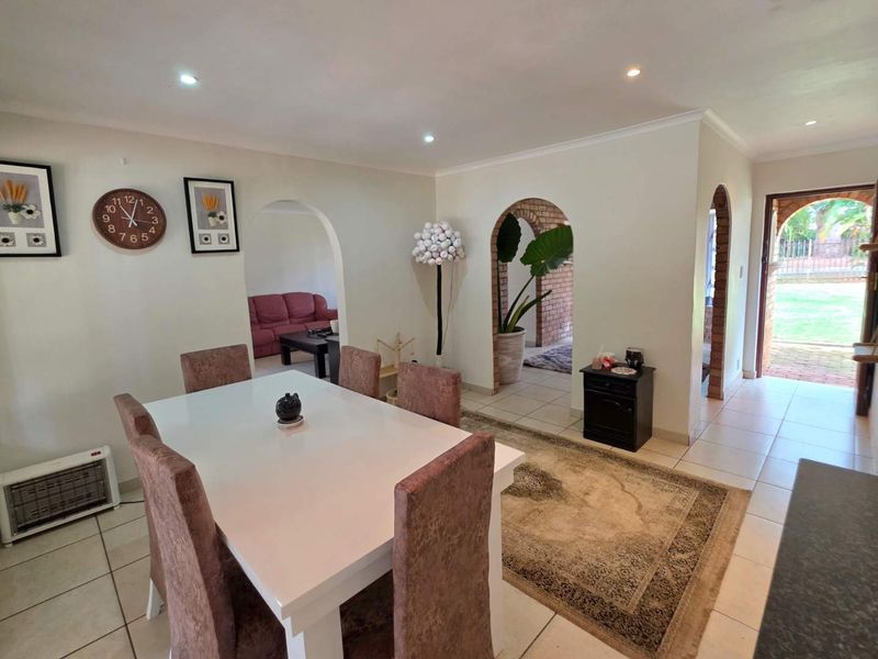 Dining area featuring tiled flooring, recessed lighting, and distinctive archways leading to adjacent living spaces and the exterior entrance.