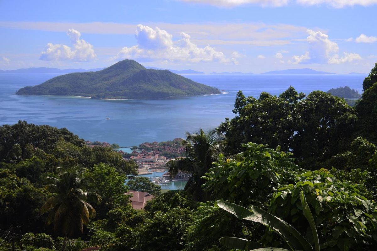 A scenic elevated view overlooking the coastline, marina, and surrounding islands, showcasing the natural beauty and landscape of the property location.